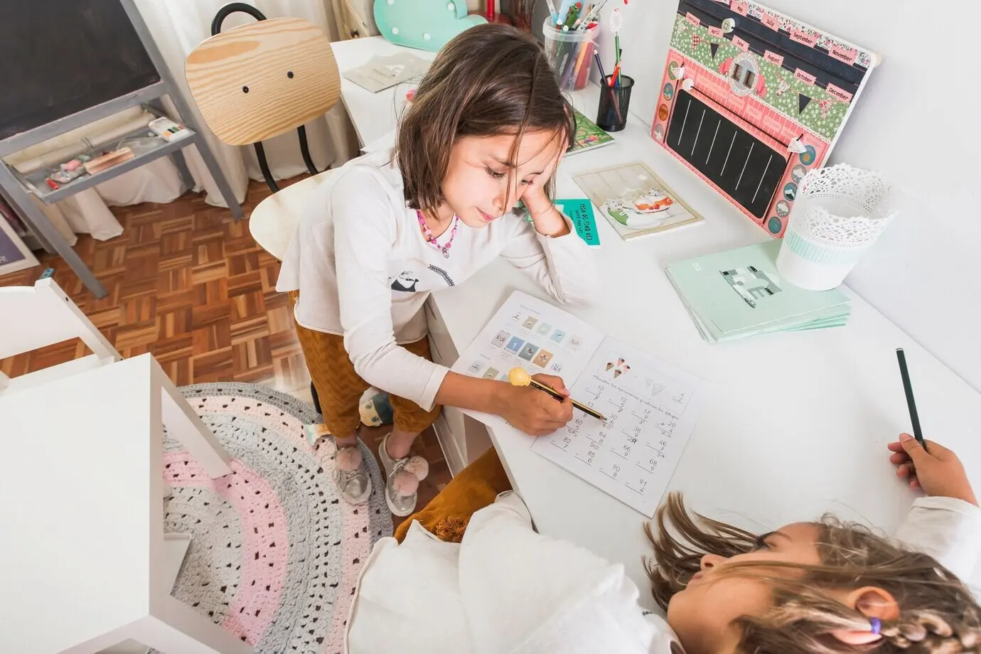 Niña ayudando a su hermana aburrida con la tarea