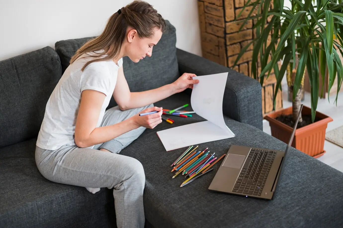Vista frontal de una mujer trabajando en un sofá.